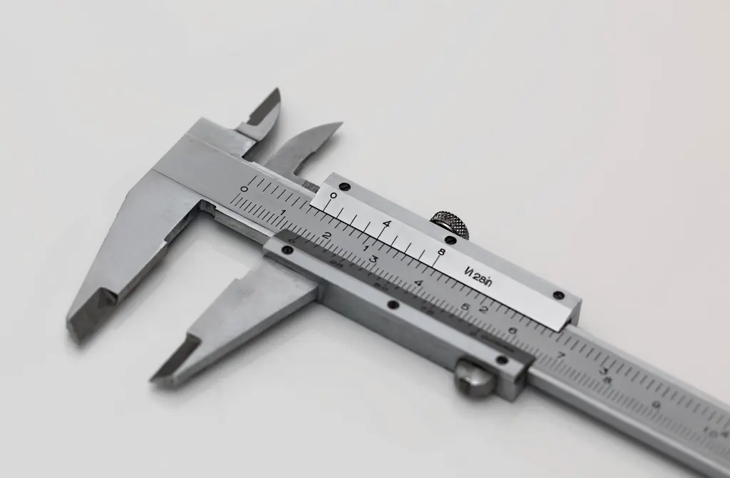 Vernier caliper measuring a machined part