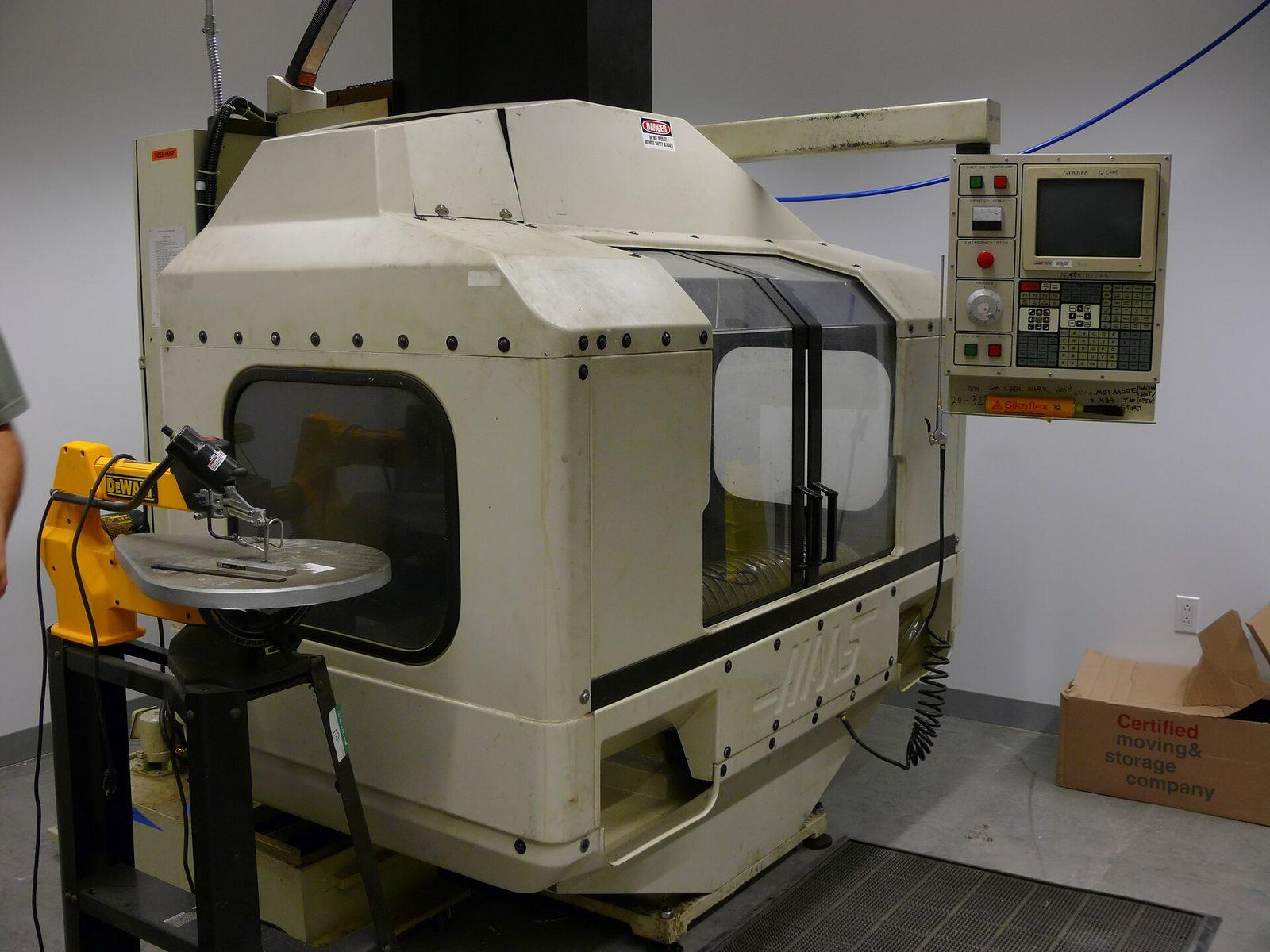 An enclosed CNC machining centre with its control pendant