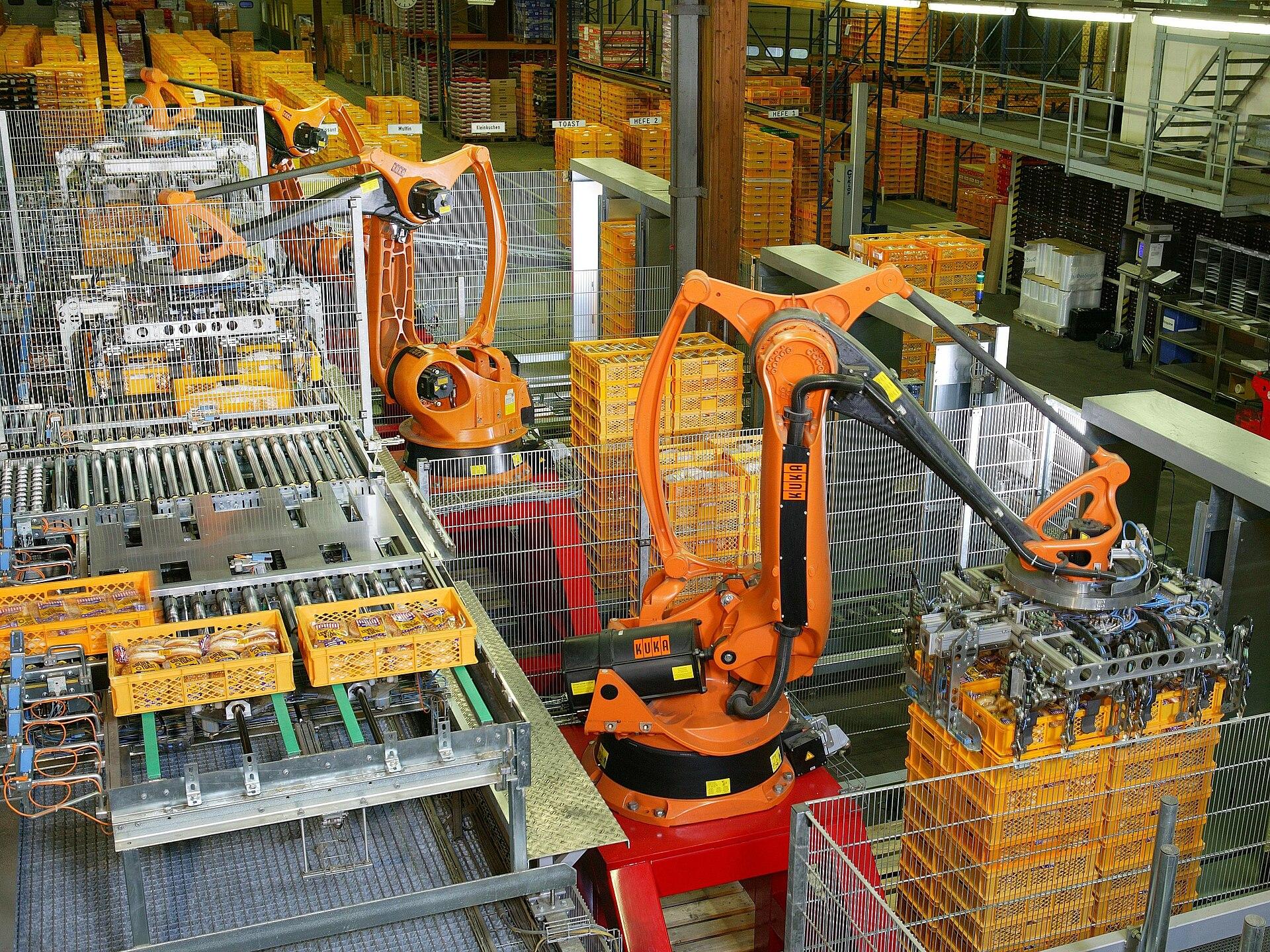 Industrial robot arms palletizing products on an automated factory line